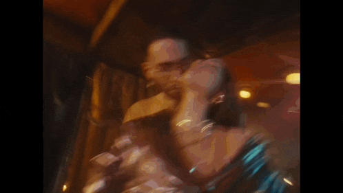 a man and woman are dancing together in a dark room .