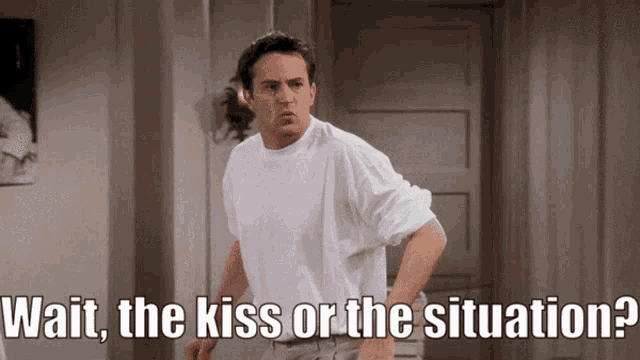 a man in a white shirt is standing in front of a door and says wait the kiss or the situation