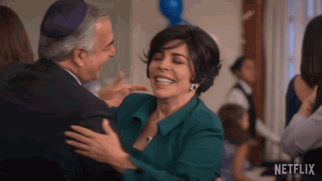 a woman in a green jacket is hugging a man in a netflix advertisement