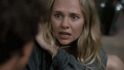 a close up of a woman making a funny face while talking to a man
