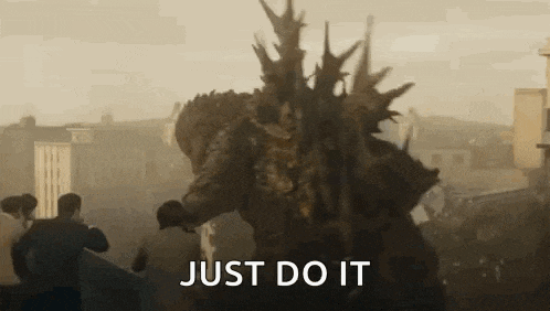a giant monster is standing in front of a crowd of people in a city and says `` just do it '' .