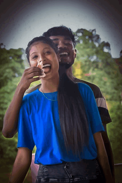 a man is feeding a woman a slice of cake