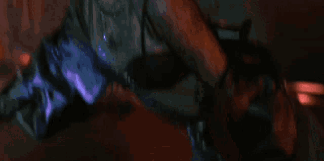 a woman with long hair is dancing in a dark room .