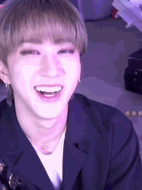 a close up of a person 's face with a purple background and a smile on their face .