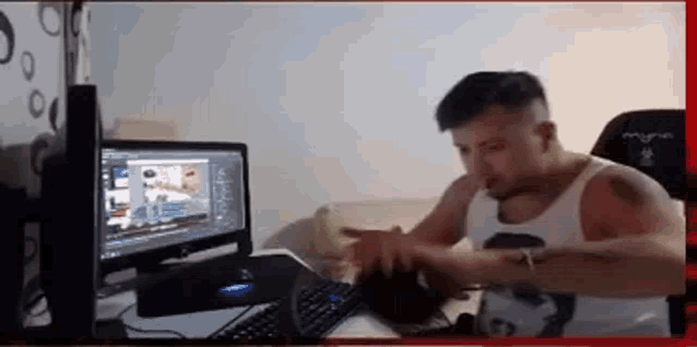 a man is sitting at a desk in front of a computer screen .