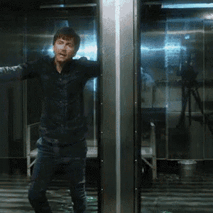 a man in a black shirt is standing in a room with his arms outstretched