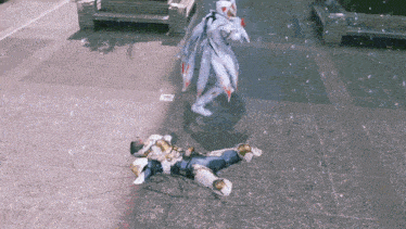 a video game character is laying on the ground while another character stands nearby