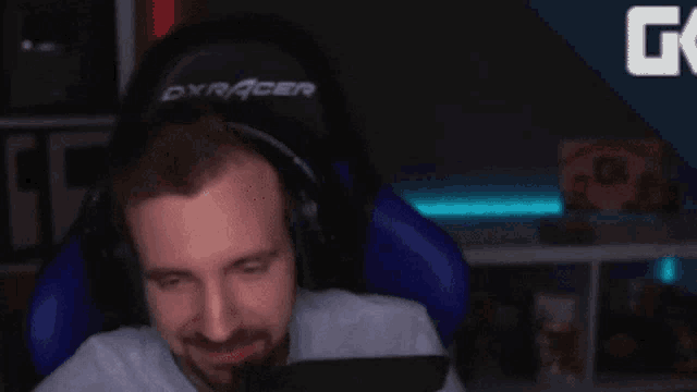 a man wearing headphones is sitting in a gaming chair