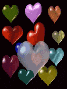 a bunch of different colored hearts are floating in the air