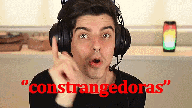 a man wearing headphones says " constrangedoras " while making a funny face
