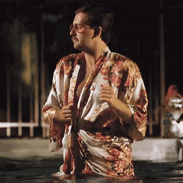 a man in a robe and sunglasses is standing in the water
