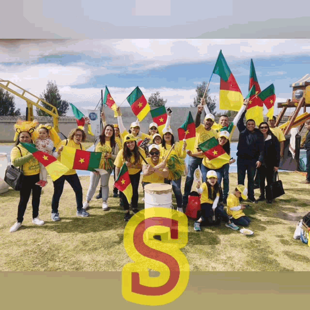 a group of people holding flags with the letter s on the bottom right