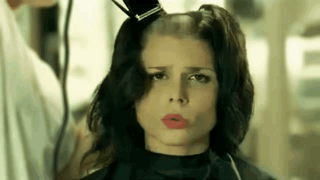 a woman is getting her hair cut by a hairdresser at a salon .