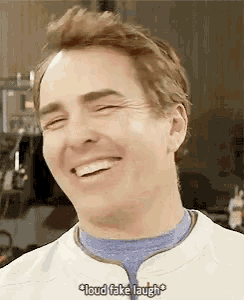 a man is smiling and saying " loud fake laugh " .
