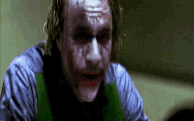 a close up of the joker 's face with a green vest