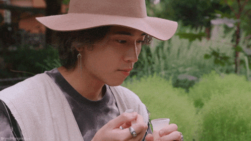 a man wearing a hat is smoking a cigarette