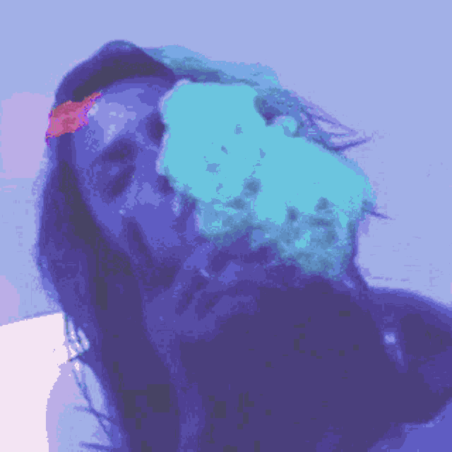 a woman is making a funny face in a purple light .