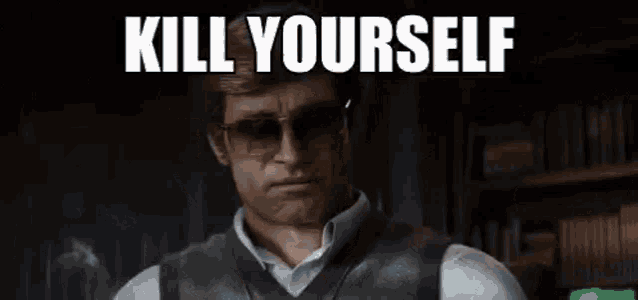 a man wearing sunglasses and a vest is standing in a dark room and says `` kill yourself '' .