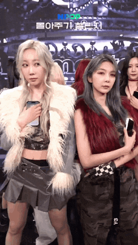 two women standing next to each other in front of a screen that says mbc