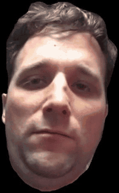 a close up of a man 's face with a sad look on his face on a black background .