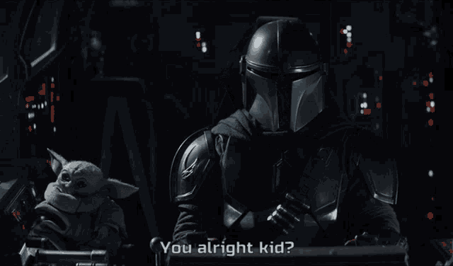 a man in a helmet is sitting next to a baby yoda and says " you alright kid "
