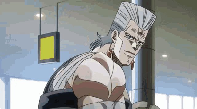 a man with a ponytail is standing next to a pole in an airport .