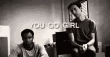 a black and white photo of two men sitting next to each other with the words `` you go girl '' behind them .