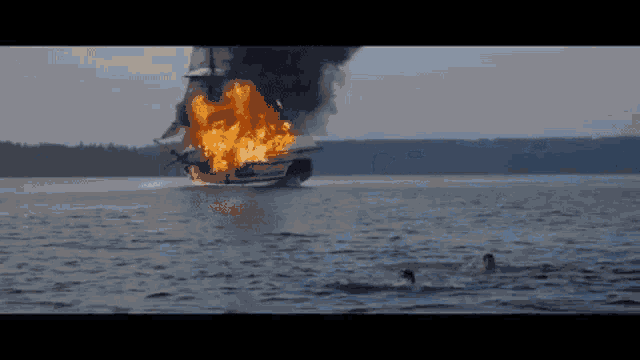a ship is on fire in the middle of the ocean .