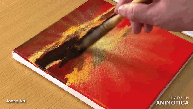 a person is painting on a canvas with the words made in animatica on the bottom right