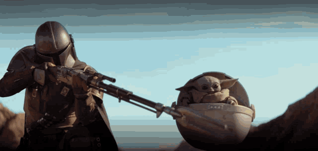 a man is holding a gun while carrying a child in a pod