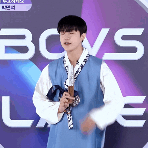 a man holding a fan in front of the word boys love