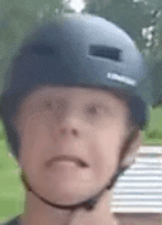 a close up of a person wearing a helmet and making a funny face .