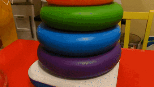 a stack of colorful rings on a red table
