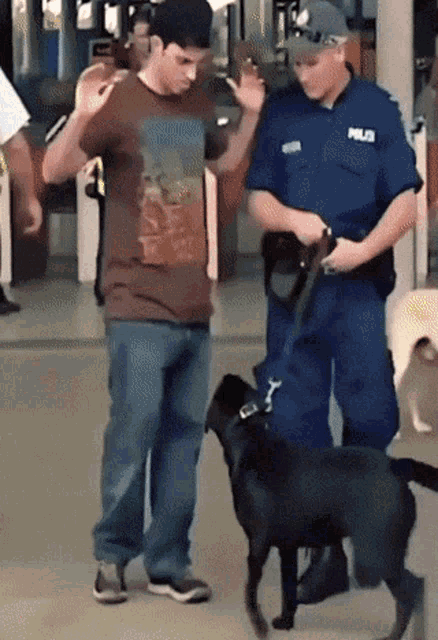 a police officer stands next to a man and a black dog