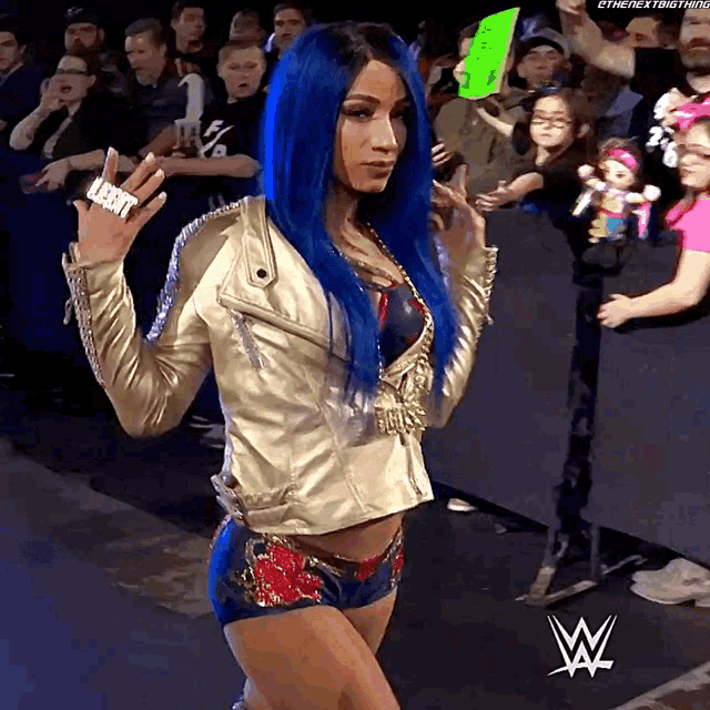 a woman with blue hair is wearing a jacket and shorts and holding a sign that says ' the next thing '