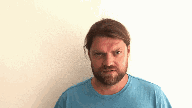 a man with a beard wearing a blue shirt