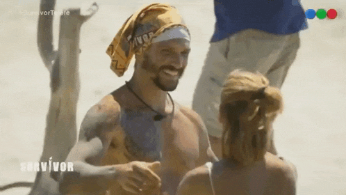 a man with a bandana on his head is talking to a woman