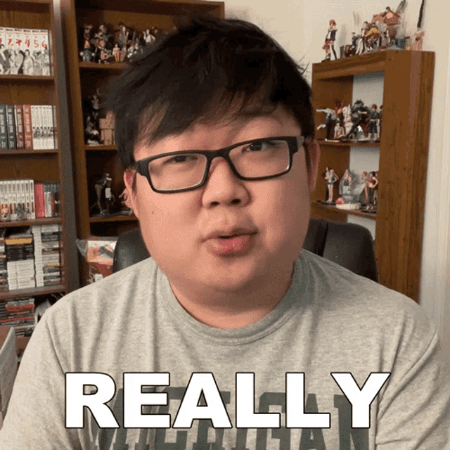 a man wearing glasses and a grey shirt with the word really on it