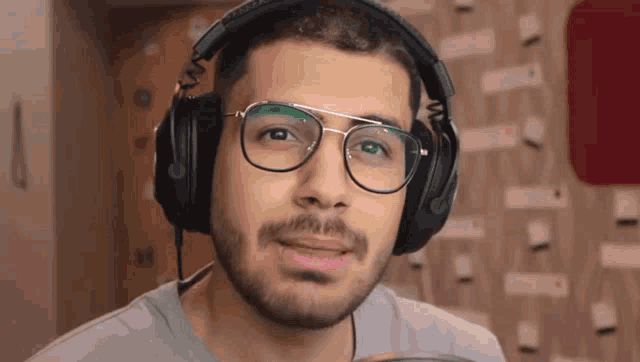 a man wearing glasses and headphones is smiling