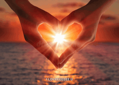 a person making a heart shape with their hands with the sun shining through them