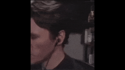 a man wearing headphones is making a funny face while looking at the camera .