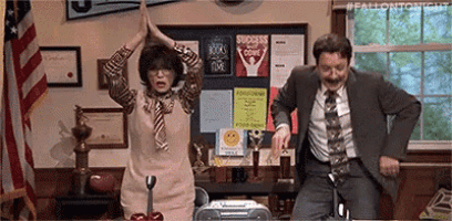 a man and a woman are giving each other a high five in an office .