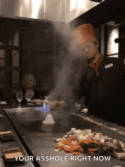 a chef is cooking food on a grill with smoke coming out of it and says your asshole right now .