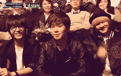 a group of people are sitting in a row in a room .