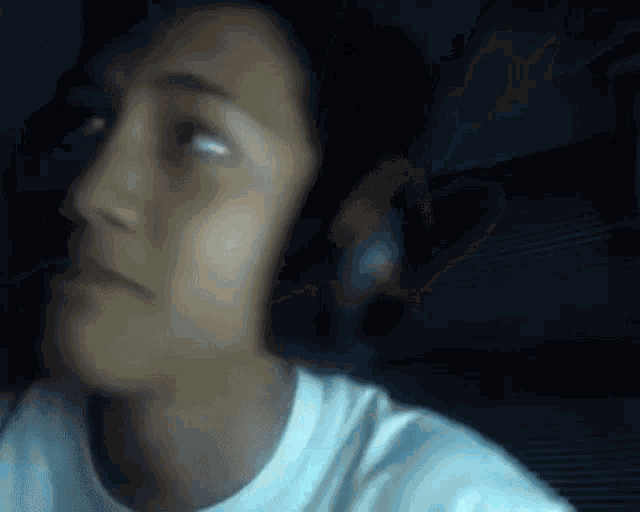 a blurry picture of a person wearing headphones and a white shirt