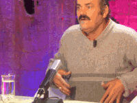 a man with a mustache is sitting at a table in front of a microphone