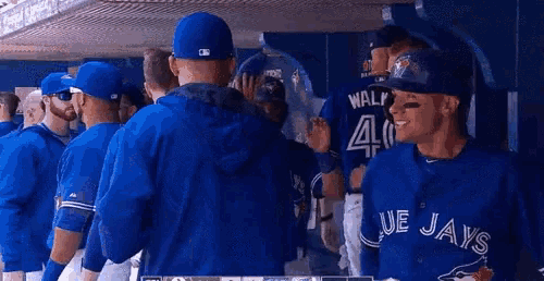 a group of blue jays players are standing in a dugout