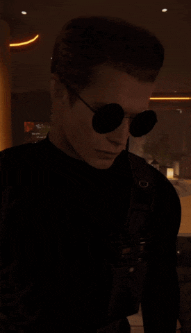 a man wearing sunglasses and a black shirt with the letter o on the chest