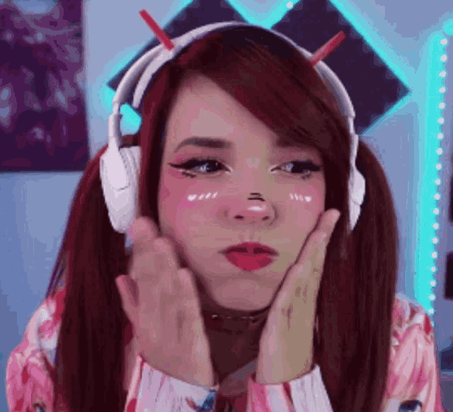 a woman wearing headphones and a choker is making a face