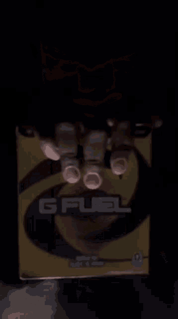 a person holding a box of gfuel in their hands